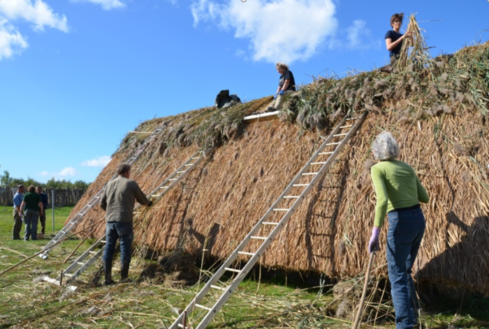 Masamuda volunteers work on roofing the reconstructed house